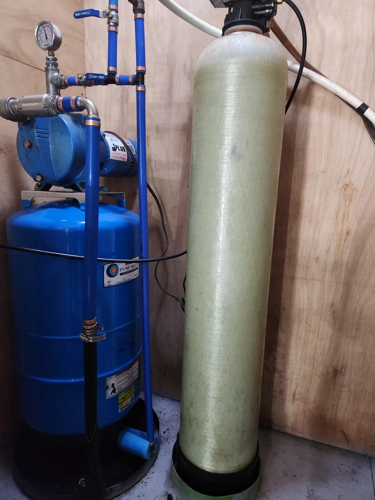 Jet pump mounted on a Pump Mate diaphragm pressure tank next to a water treatment tank
