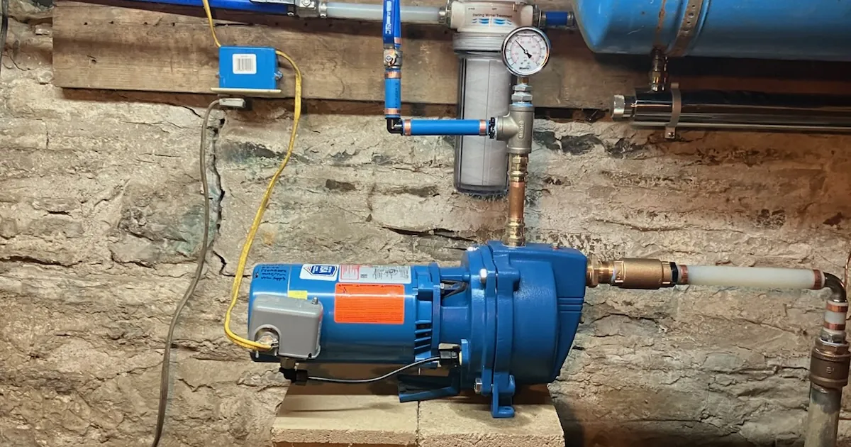 Jet pump with pressure gauge, pressure switch and sediment filter on a fieldstone basement wall in a central New York home
