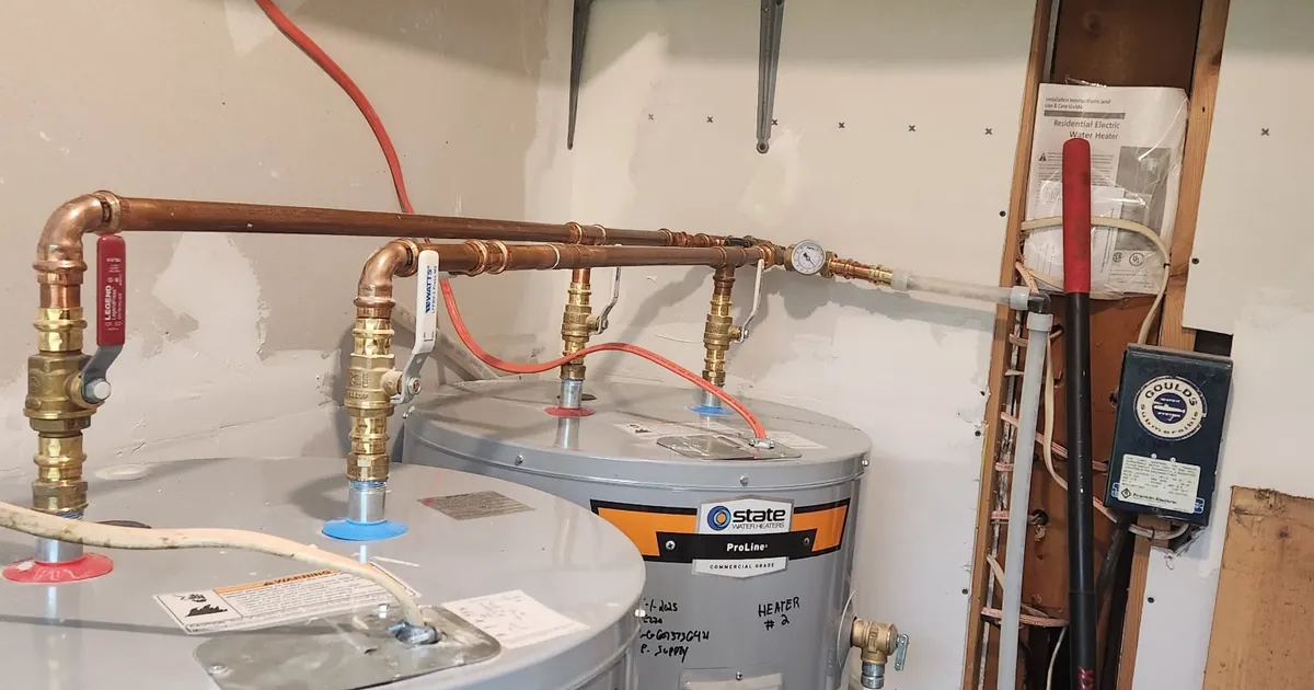 Two State ProLine electric water heaters piped in parallel with copper press fittings, isolation ball valves and a pressure gauge installed by EZ-CO Plumbing