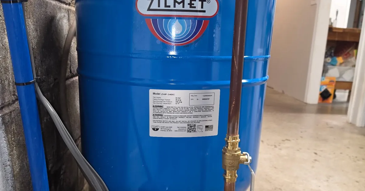 New Zilmet well pressure tank with copper supply line and brass shutoff valve installed by EZ-CO Plumbing in a central New York basement